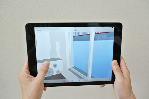 iPadを手に持ち、モバイル版BIM 360 Glue Mobileで表示される画像が移動する操作をしているところ